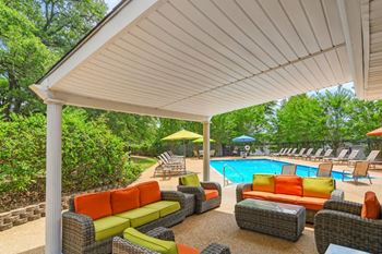 A patio with couches and a pool in the background