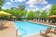 Mccomb apartment for rent - our resort style pool is filled with chairs and umbrellas at Parklane Apartment Homes, Mississippi