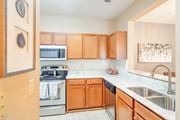 Olive Branch apartment for rent - a kitchen with wooden cabinets and stainless steel appliances at The Vineyard of Olive Branch Apartment Homes, Mississippi 38654