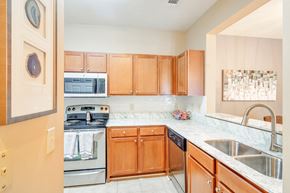 Olive Branch apartment for rent - a kitchen with wooden cabinets and stainless steel appliances at The Vineyard of Olive Branch Apartment Homes, Mississippi 38654