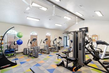 A gym with a variety of equipment including a treadmill, stationary bike, and weight machine