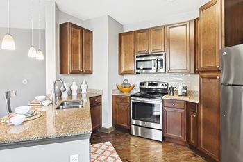 A kitchen with wooden cabinets and a granite countertop