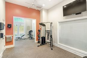 Biloxi apartment for rent - a home gym with exercise equipment and a tv at Lagniappe of Biloxi Apartment Homes, Biloxi, MS, 39532