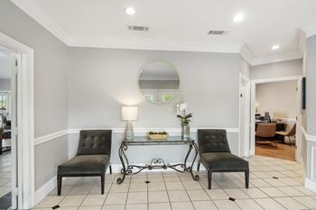 A living room with two black chairs and a glass table