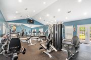 Gautier apartment for rent - a gym with cardio machines and weights on the floor at The Pointe Apartment Homes in Mississippi 39553