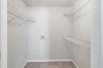 An empty closet with white walls and shelves and a white walled closet with shelves