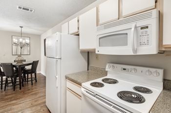 A kitchen with a stove microwave and refrigerator