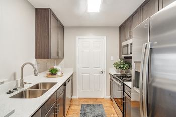 An empty kitchen with stainless steel appliances and a sink