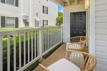 A patio with two chairs and a table on a balcony