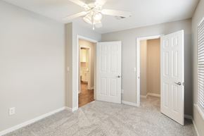 Meridian apartment for rent - an empty bedroom with white doors and a ceiling fan at The Woodlands Apartment Homes, Meridian, Mississippi