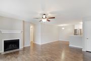 Meridian apartment for rent - an empty living room with a ceiling fan and a fireplace at The Woodlands Apartment Homes, Meridian, MS, 39301