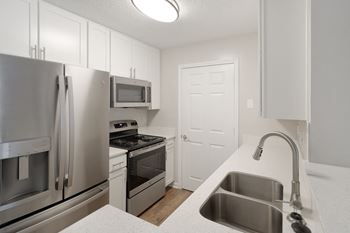 A kitchen with stainless steel appliances and white cabinets 