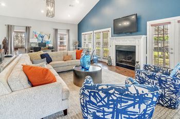 A living room with blue and white furniture and a fireplace