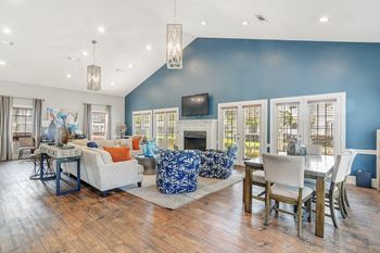 A living room and dining room with blue walls and a fireplace