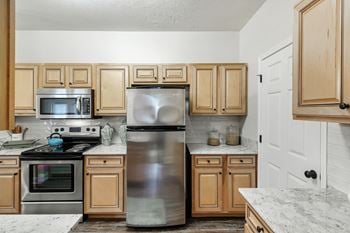 A kitchen with stainless steel appliances and wooden cabinets
