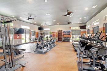 Gym with cardio equipment and a large window
