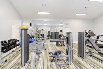 A gym with a variety of equipment including weights and cardio machines