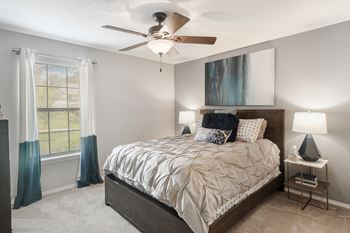 A bedroom with a bed and a ceiling fan at parkwest apartment homes in hattiesburg ms