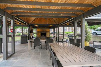 A wooden table is in the middle of a patio