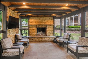 A patio with a fireplace and chairs