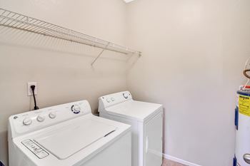 A white washing machine and dryer in a laundry room