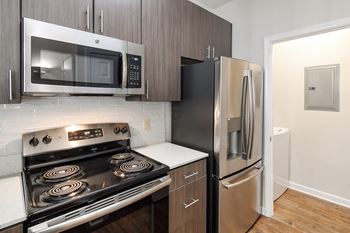 A kitchen with stainless steel appliances and a refrigerator