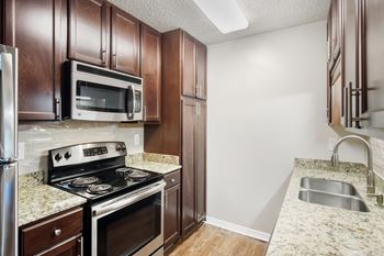 A kitchen with a stove, microwave, and refrigerator