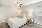 Brandon apartment for rent - a bedroom with a large white bed and a ceiling fan at Lakeshore Pointe Apartment Homes, Brandon, MS