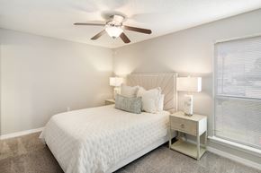 Brandon apartment for rent - a bedroom with a large white bed and a ceiling fan at Lakeshore Pointe Apartment Homes, Brandon, MS