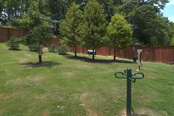 A backyard with trees and sculptures in the grass