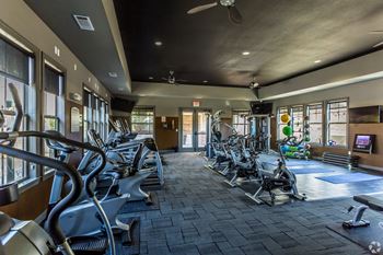 A gym with treadmills, elliptical machines, and other exercise equipment