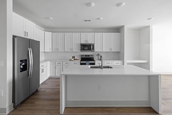 A modern kitchen with white cabinets and a large island.