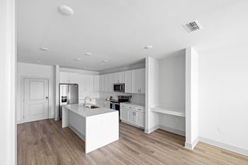 A modern kitchen with white cabinets and a white island.