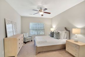 Flowood apartment for rent - a bedroom with a bed and a ceiling fan at Ashford Place Apartment Homes, Flowood, 39232