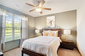 Zachary apartment for rent - a bedroom with a large bed and a ceiling fan at Audubon Park Apartment Homes, Louisiana, 70791