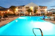 Starkville apartment for rent - a swimming pool at night with a hotel in the background at Avalon Apartment Homes, Starkville, 39759
