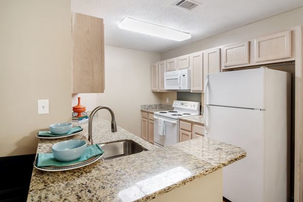 Starkville apartment for rent - a kitchen with white appliances and a granite counter top at Avalon Apartment Homes, Starkville, 39759