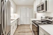 Olive Branch apartment for rent - a kitchen with white cabinets and stainless steel appliances and a refrigerator at The Oliver Apartment Homes, Olive Branch, MS, 38654