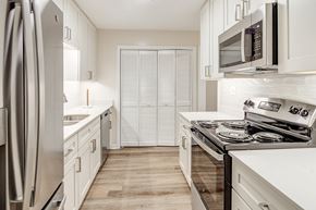 Olive Branch apartment for rent - a kitchen with white cabinets and stainless steel appliances and a refrigerator at The Oliver Apartment Homes, Olive Branch, MS, 38654