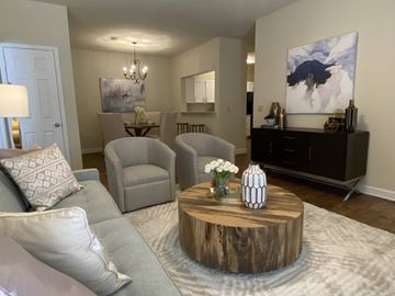 Shreveport apartment for rent - A living room with a grey couch, a wooden coffee table, and a painting on the wall.