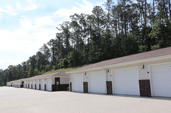 A row of garages with white doors and a roof