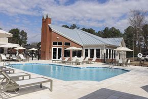 Flowood apartment for rent - A pool with a building behind it at Carlton Park Apartment Homes in Flowood, MS 