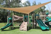 Brandon apartment for rent - A playground with a green slide and a brown and green play structure.