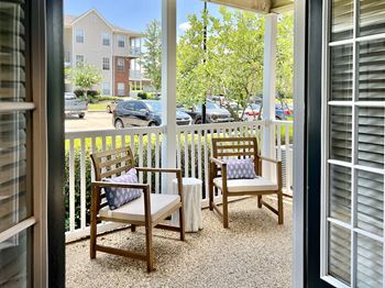 Two chairs and a bench are on a patio at park place apartment homes in hattiesburg, ms.