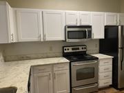 Shreveport apartment for rent - A kitchen with white cabinets and a black fridge at Summit of Shreveport Apartments, Shreveport, LA, 71105