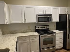 Shreveport apartment for rent - A kitchen with white cabinets and a black fridge at Summit of Shreveport Apartments, Shreveport, LA, 71105