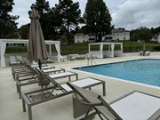 Laurel apartment for rent - a swimming pool with chairs and an umbrella next to it at Laurelwood Apartment Homes, Mississippi, 39440
