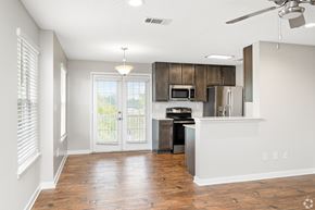 Hattiesburg apartment for rent - A kitchen with a refrigerator, microwave, and stove top oven. at Reserve at Park Place Apartment Homes, Hattiesburg, MS, 39402