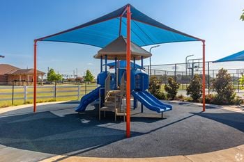 A playground with a blue slide and a canopy