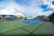 Bossier City apartment for rent - two tennis courts with houses and a playground in the background at Reserve of Bossier City Apartment Homes in Bossier City, Louisiana 71111